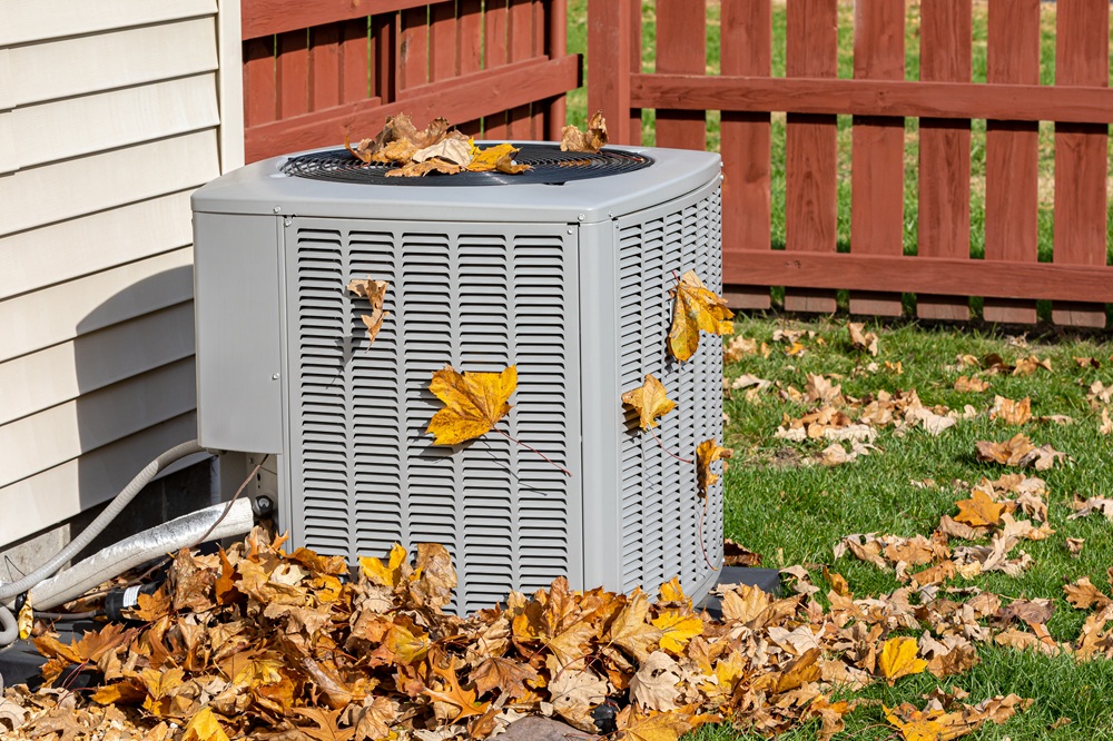Autumn leaves falling on an HVAC unit