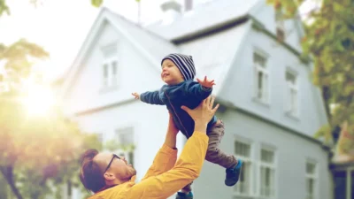 Father and son playing in front of a Massachusetts home in chilly weather