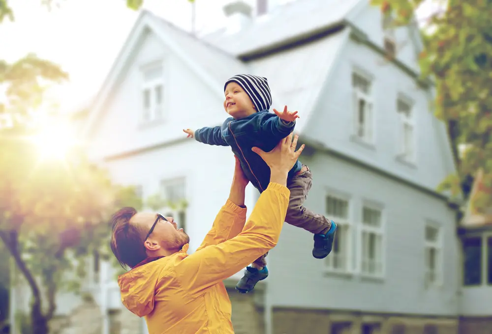 Father and son playing in front of a Massachusetts home in chilly weather