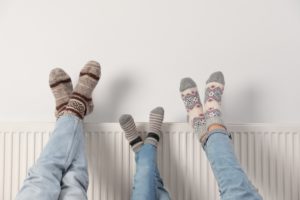 Family props their feet up on the radiator with cozy winter socks