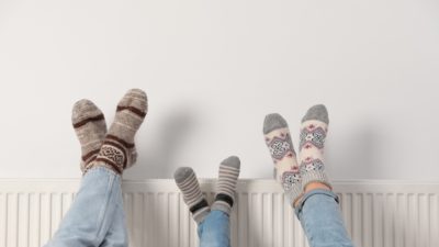 Family props their feet up on the radiator with cozy winter socks