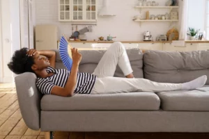 Massachusetts Woman Fanning Herself on Couch in Her Home